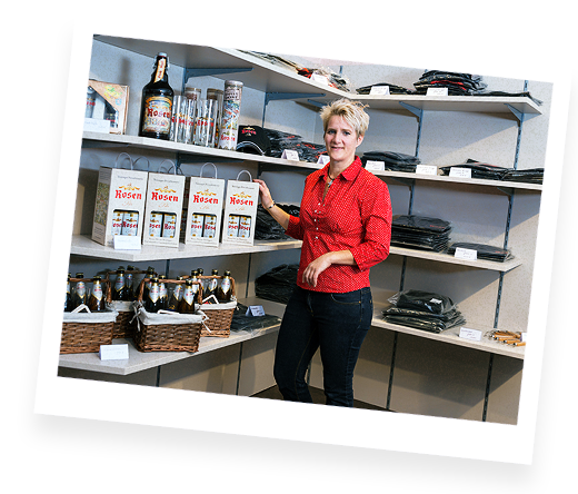 Eine Mitarbeiterin vor einem Regal im Fan-Shop der Rosenbrauerei